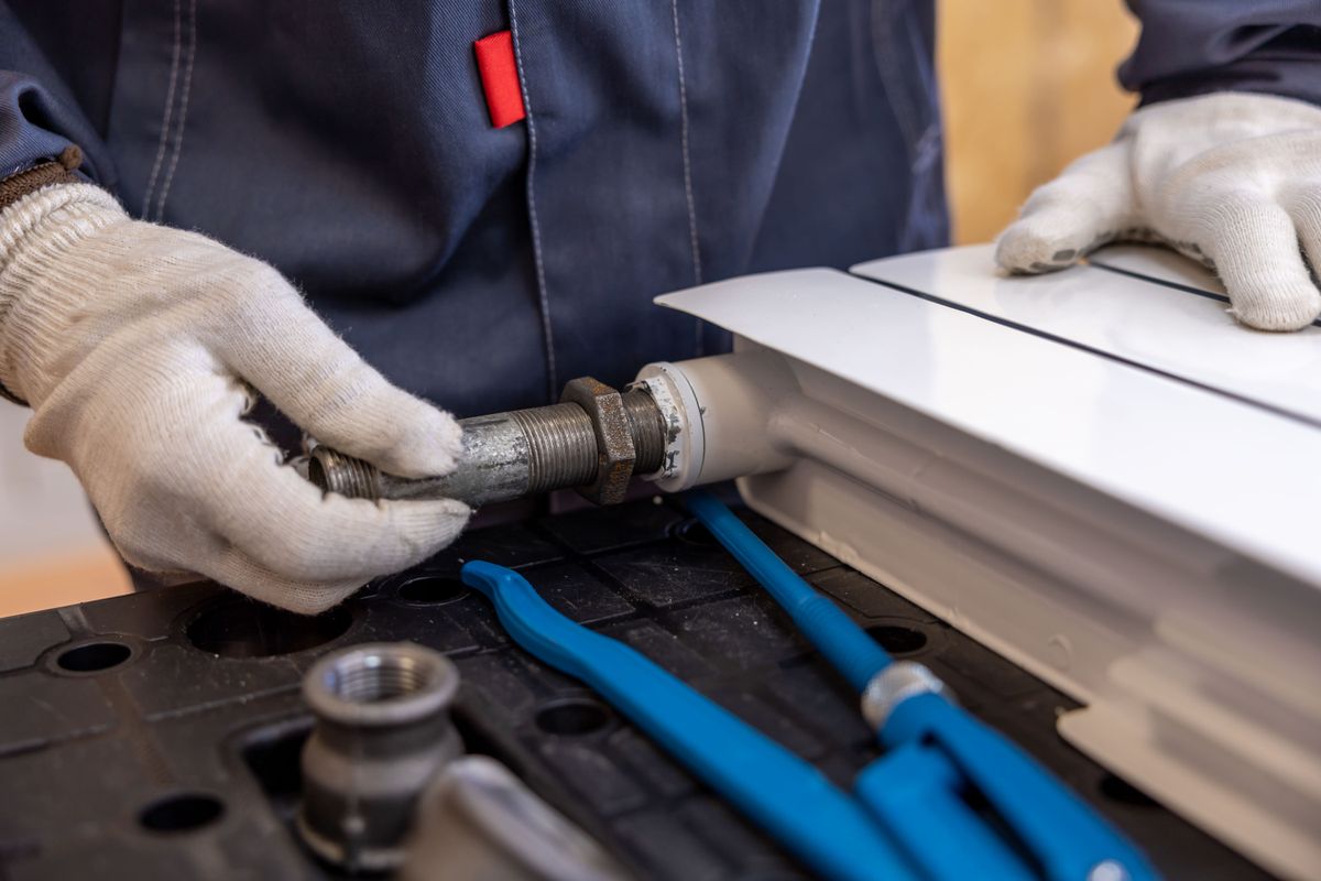 Fitting a radiator valve and tail — additional and designer radiators installed to bring cold rooms up to temperature.